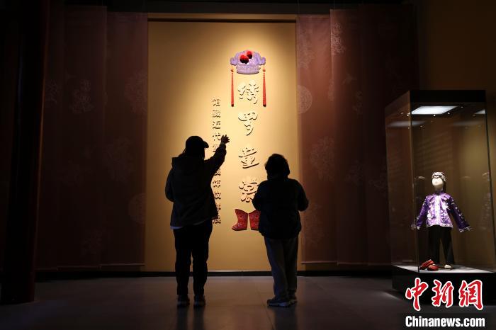 山西太原，民眾正在參觀《繡羅童裳——館藏近代童衣裝飾紋樣展》?！?jiān)?攝
