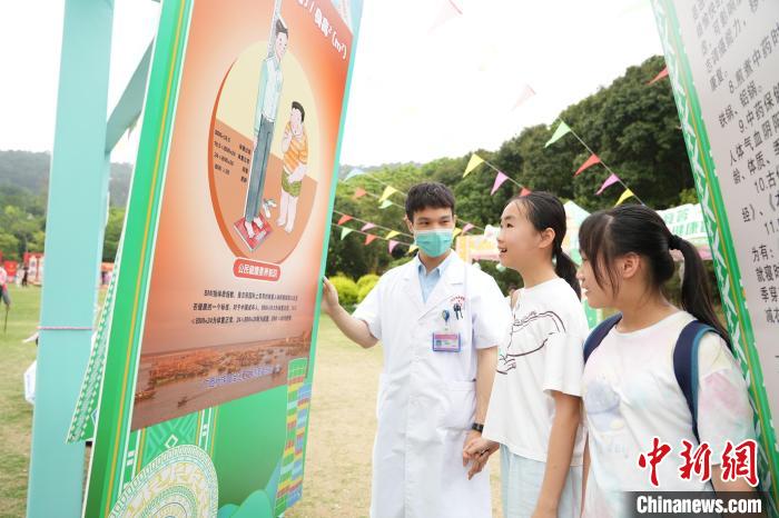 圖為廣西醫(yī)護(hù)人員向民眾介紹公民健康素養(yǎng)知識?！V西壯族自治區(qū)衛(wèi)生健康委員會供圖