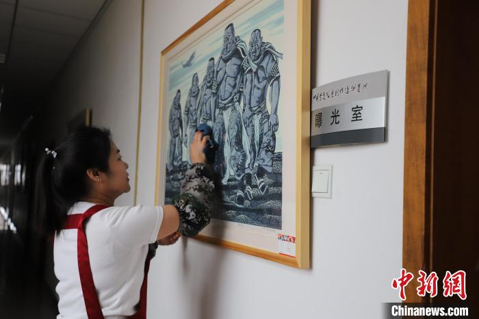 圖為王秀春在擦拭版畫作品?！埩只?攝