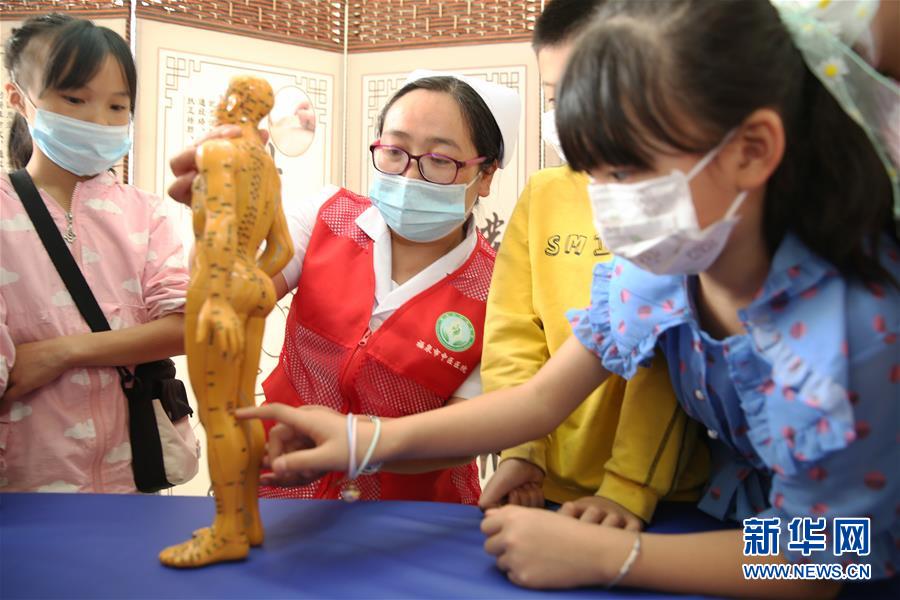 5月31日，在貴州省黔南布依族苗族自治州福泉市中醫(yī)醫(yī)院，醫(yī)務(wù)人員向小朋友介紹人體穴位知識。 新華社發(fā)（黃歡 攝）