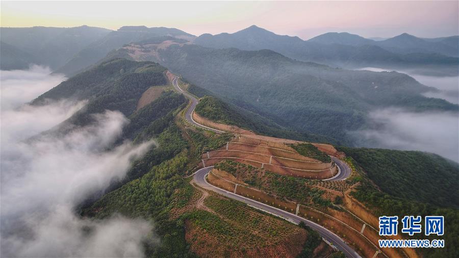 7月28日拍攝的鳳翅山至蟒頭山國(guó)家森林公園全域旅游示范路（無(wú)人機(jī)照片）。 位于陜西省延安市宜川縣鳳翅山至蟒頭山國(guó)家森林公園間的全域旅游示范路沿途風(fēng)景優(yōu)美，時(shí)?？梢姺v的云海。示范路方便旅客觀賞沿線叢林山水，也輻射帶動(dòng)了沿線3個(gè)貧困村的村民脫貧致富。 新華社發(fā)（趙潔 攝）