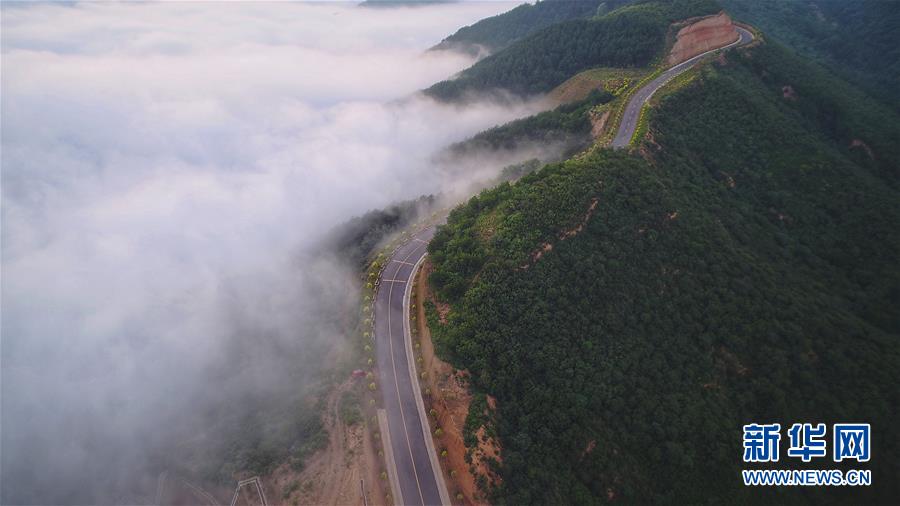7月28日拍攝的鳳翅山至蟒頭山國(guó)家森林公園全域旅游示范路（無(wú)人機(jī)照片）。 位于陜西省延安市宜川縣鳳翅山至蟒頭山國(guó)家森林公園間的全域旅游示范路沿途風(fēng)景優(yōu)美，時(shí)?？梢姺v的云海。示范路方便旅客觀賞沿線叢林山水，也輻射帶動(dòng)了沿線3個(gè)貧困村的村民脫貧致富。 新華社發(fā)（趙潔 攝）