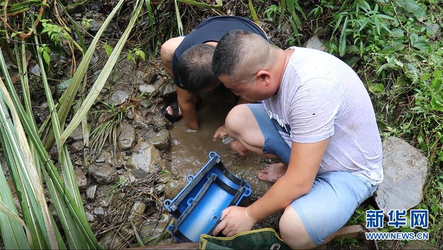 月12日，湖南省張家界市桑植縣陳家河鎮(zhèn)供水站站長廖濤與王波在管道漏水點(diǎn)安裝搶修節(jié)。新華社記者 蔡瀟瀟 攝