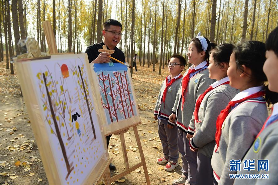 11月4日，滄州市實(shí)驗(yàn)小學(xué)的老師指導(dǎo)學(xué)生繪畫。 深秋時(shí)節(jié)，河北省滄州市實(shí)驗(yàn)小學(xué)美術(shù)興趣小組的學(xué)生在老師的帶領(lǐng)下走出教室，走進(jìn)大自然，以“多彩森林”為主題，用畫筆描繪斑斕秋色。 新華社發(fā)（傅新春 攝）