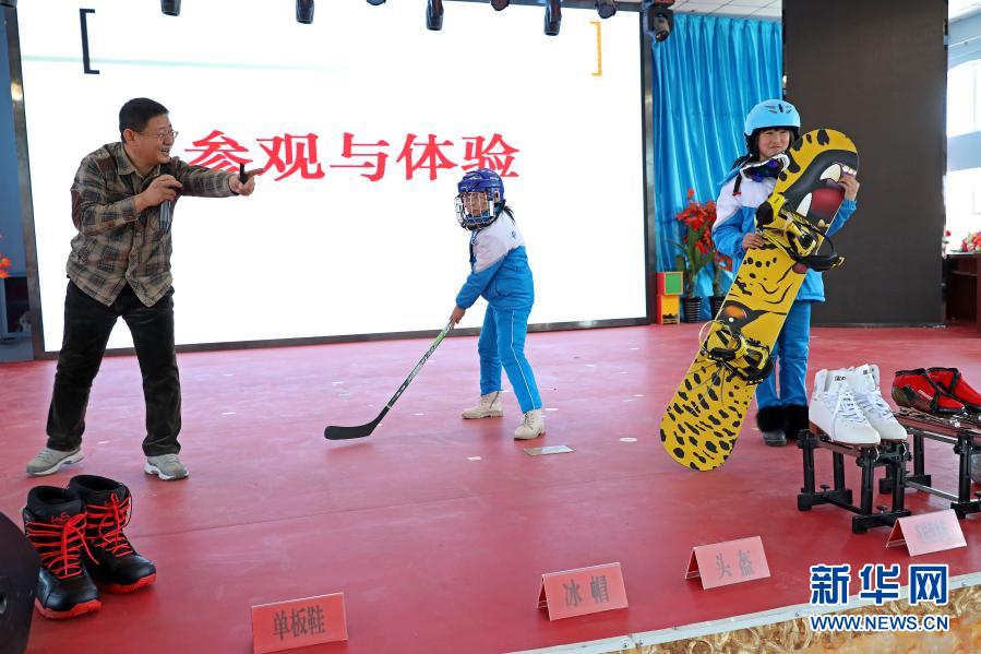 12月1日，河北省尚義縣大青溝鎮(zhèn)中心小學(xué)學(xué)生在體驗(yàn)冰雪運(yùn)動(dòng)項(xiàng)目的器材和裝備。當(dāng)日，由河北省張家口市科學(xué)技術(shù)協(xié)會(huì)主辦的“冬奧科普知識(shí)進(jìn)校園”活動(dòng)走進(jìn)尚義縣大青溝鎮(zhèn)中心小學(xué)、尚義縣第三中學(xué)，給學(xué)生們講授冰雪體育運(yùn)動(dòng)項(xiàng)目和冬季奧運(yùn)會(huì)的相關(guān)知識(shí)，讓學(xué)生們加深對(duì)冰雪運(yùn)動(dòng)和奧運(yùn)會(huì)的了解，激發(fā)青少年參與冰雪運(yùn)動(dòng)的熱情。新華社發(fā)（武殿森 攝）