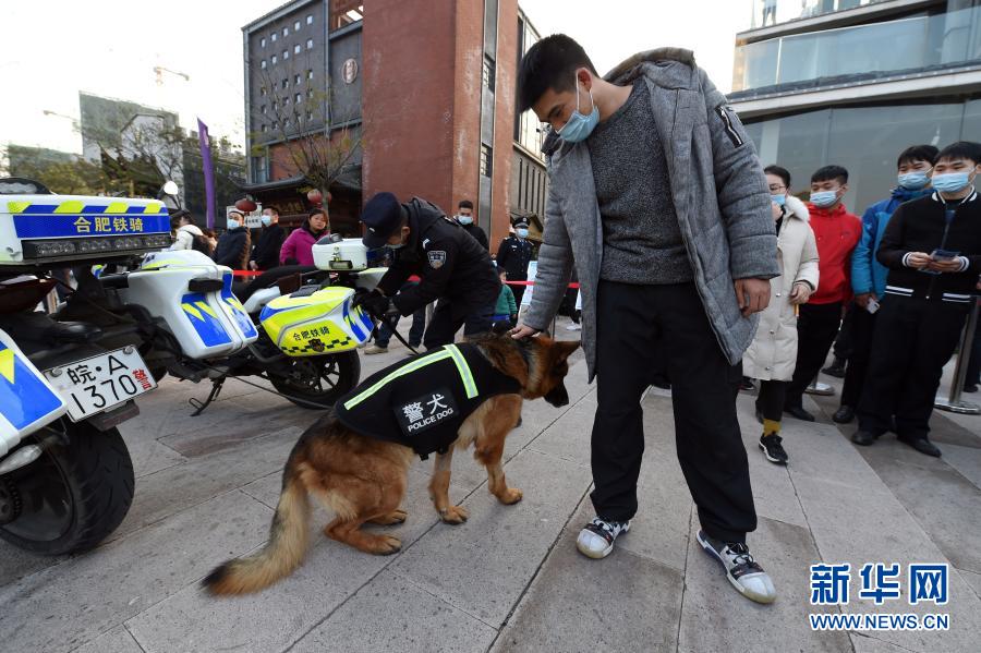 12月4日，市民在合肥市包河區(qū)警營開放日活動現(xiàn)場和警犬互動。當(dāng)日，合肥市包河區(qū)舉辦警營開放日活動，現(xiàn)場設(shè)立多個主題互動展區(qū)，市民可以近距離接觸警務(wù)裝備，進行警種業(yè)務(wù)咨詢，并參與趣味知識競答等活動。新華社記者 周牧 攝