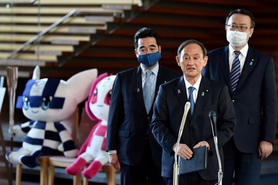11月16日，日本首相菅義偉（中）在與國際奧委會主席巴赫舉行會談后接受采訪。新華社/路透