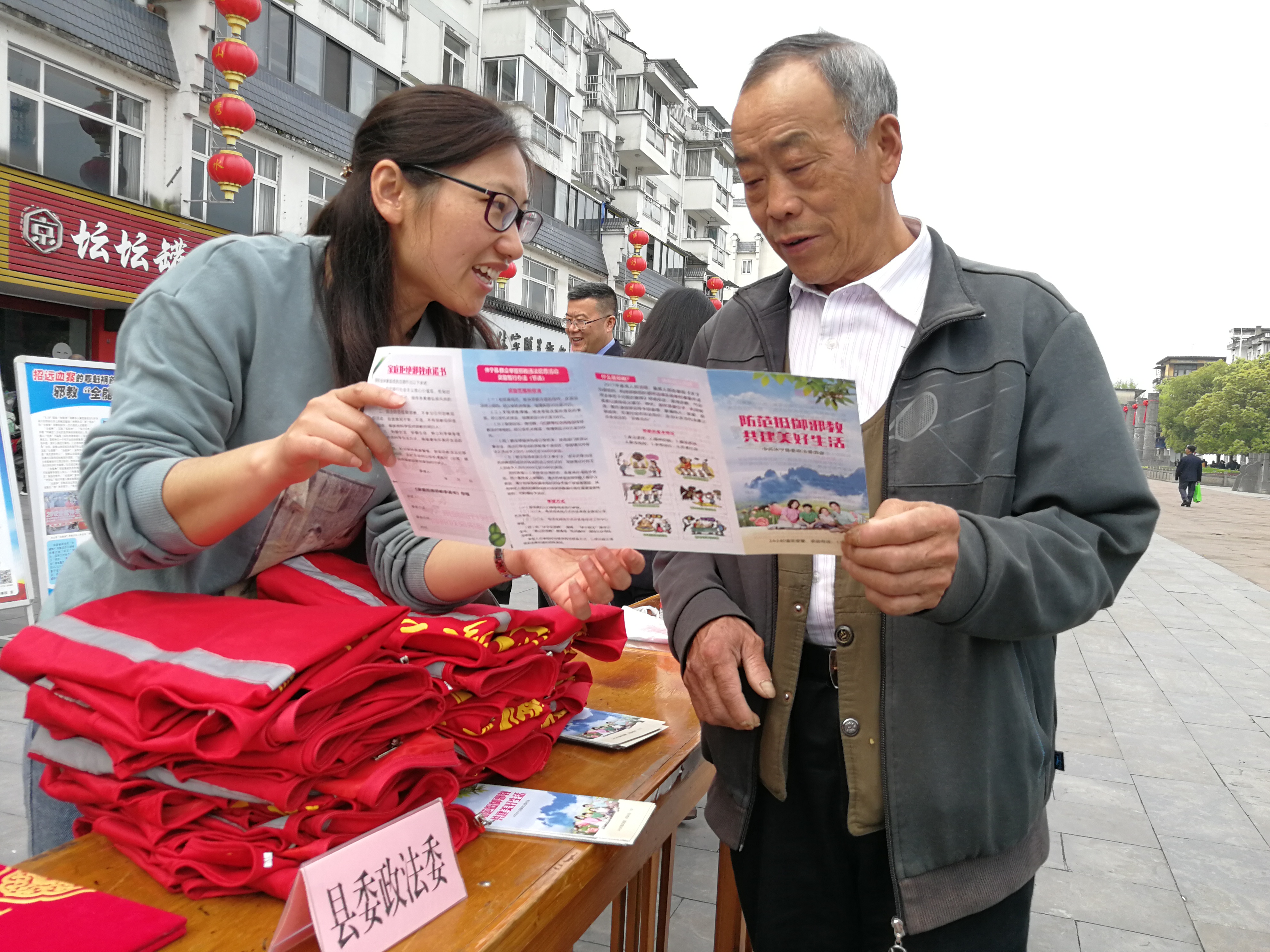 休寧縣政法委工作人員向群眾發(fā)放反邪教宣傳冊(cè)，介紹反邪教基本常識(shí)